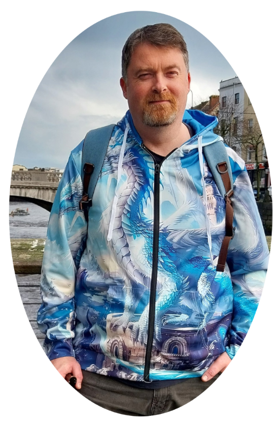 Author Darren Joy standing by a riverside walkway with a bridge in the background